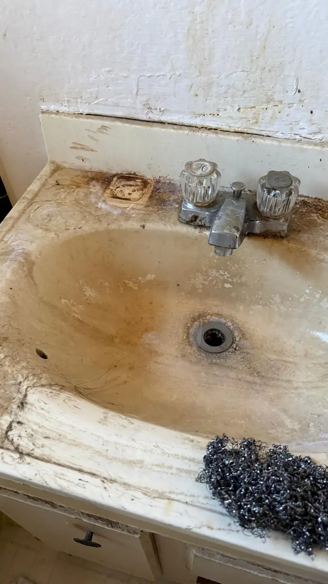 Bathroom sink with dried residue and grime before cleanup