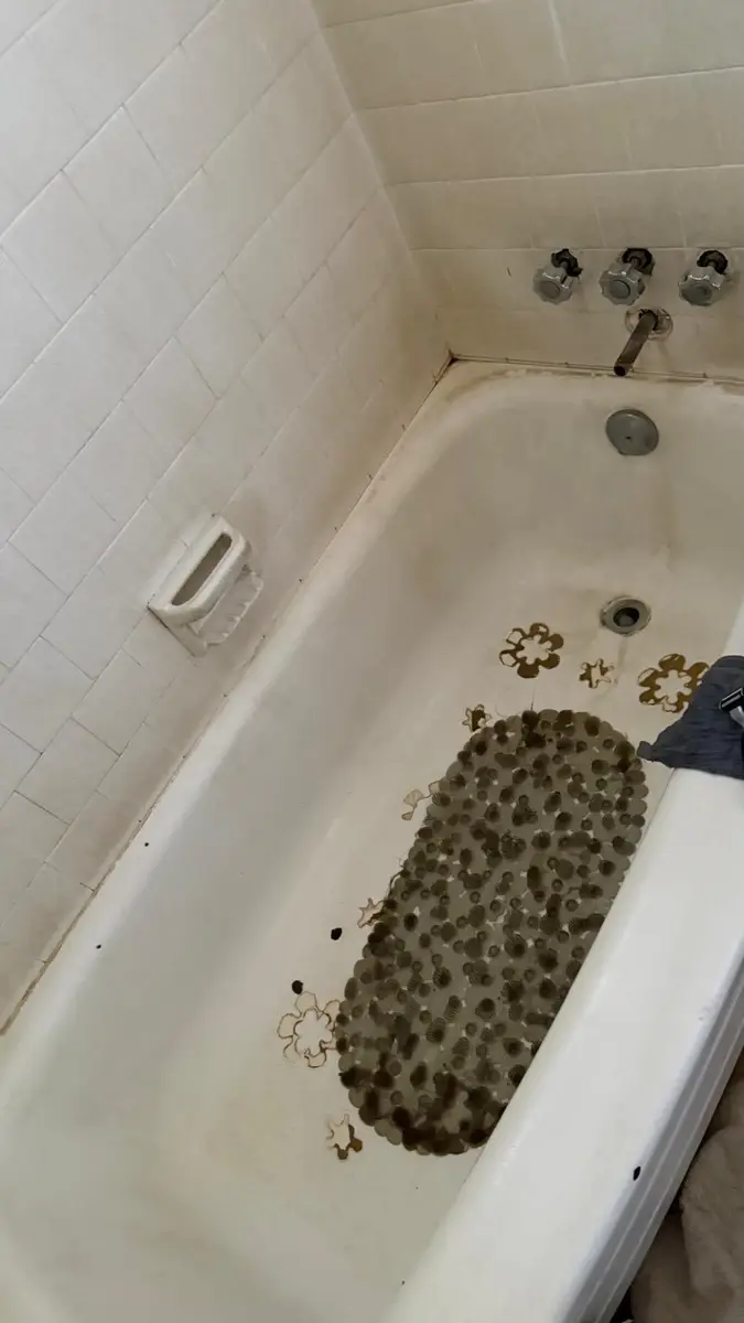 Bathtub with heavy staining and buildup before cleanup
